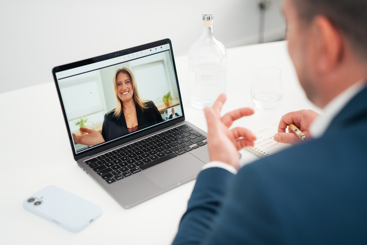Laptop in einem Onlinetermin, Bildschirm zeigt die Besprechung