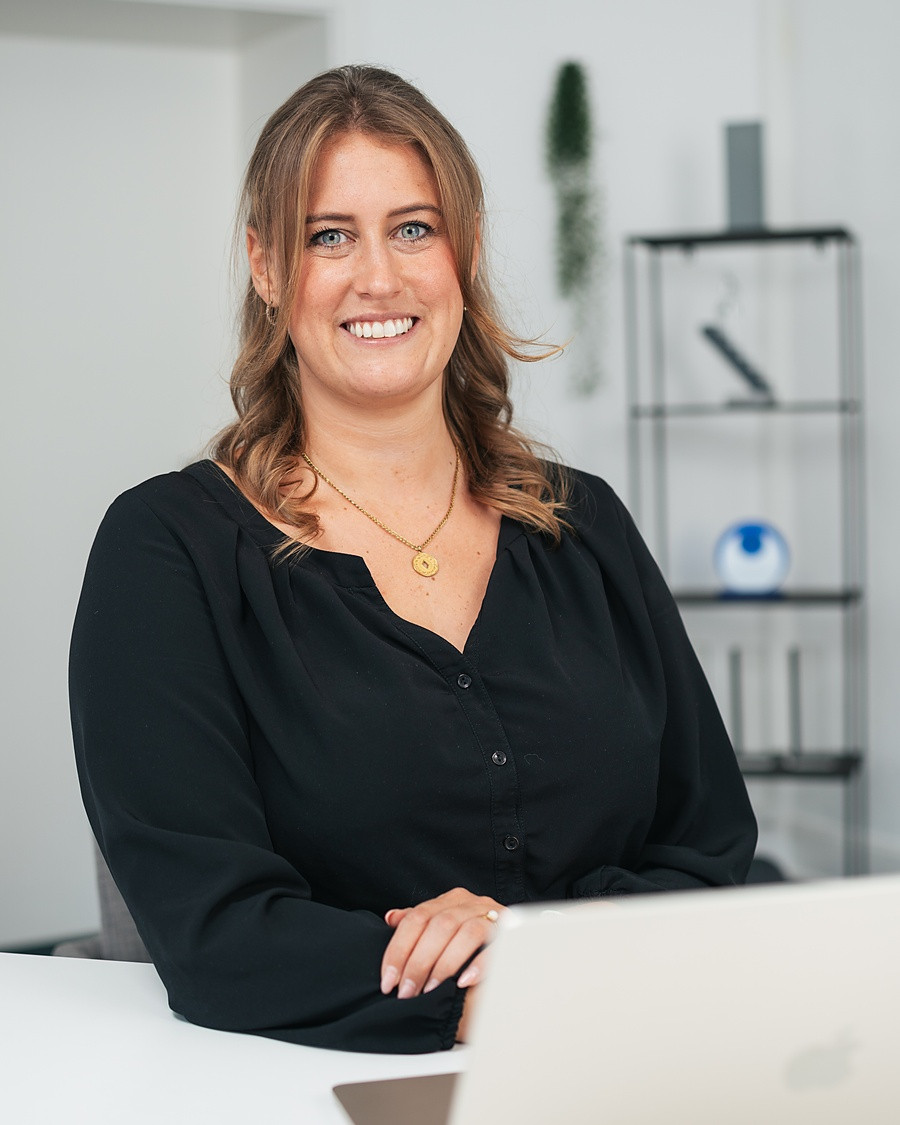 Fabienne Hermann am Schreibtisch, zugewandt und im Gespräch